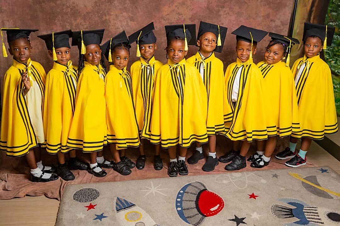 Herons children in graduation gowns